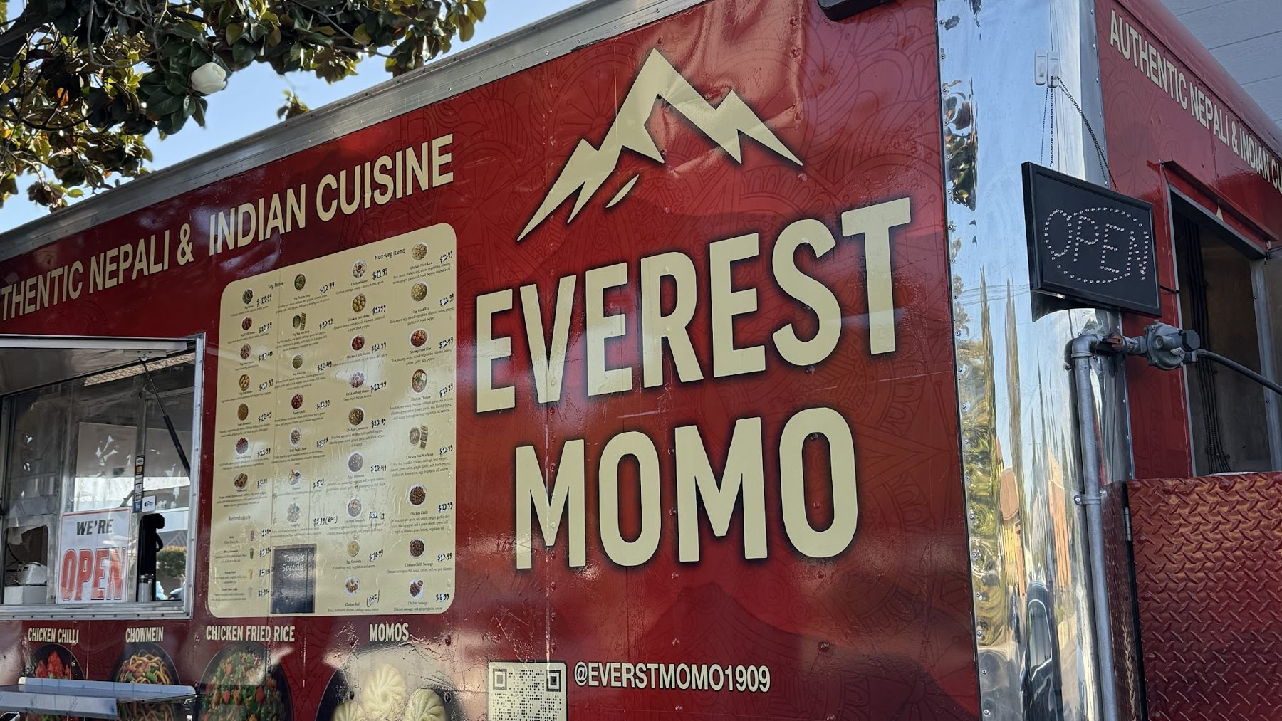 The red Everest Momo food truck with its cream mountain logo